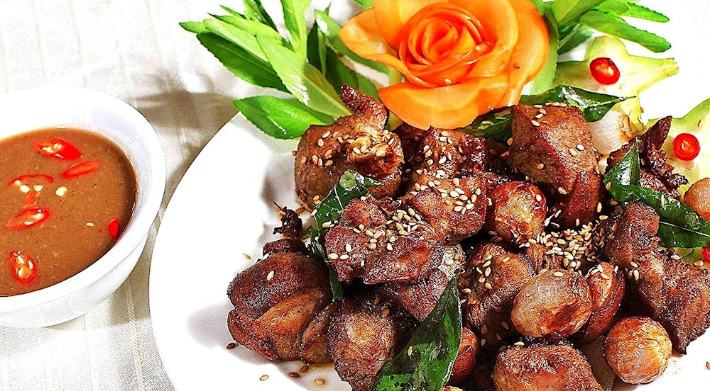 The dish is typically served with a side of pickled vegetables, fresh herbs, and rice or bread, offering a balanced and satisfying meal